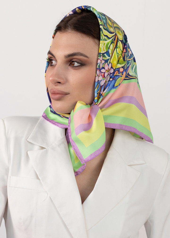 Frau trägt Designer Seidentuch Zauberwald Morgen 65×65 cm aus Twill-Seide, als Kopftuch gebunden, florales Muster und Pastellrand