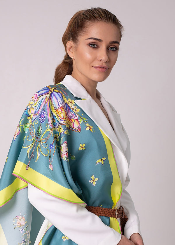 Designer Seidenschal „Emerald Butterfly“ in Smaragdgrün – elegantes Seidentuch aus Twill-Seide mit handgezeichnetem Schmetterlingsmotiv, getragen zu weißem Outfit. Kunstvolles Design von Iryna Feinblatt.