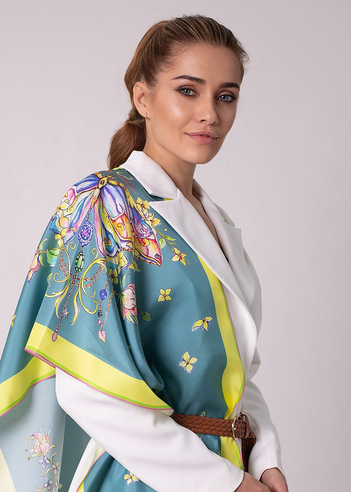 Designer Seidenschal „Emerald Butterfly“ in Smaragdgrün – elegantes Seidentuch aus Twill-Seide mit handgezeichnetem Schmetterlingsmotiv, getragen zu weißem Outfit. Kunstvolles Design von Iryna Feinblatt.