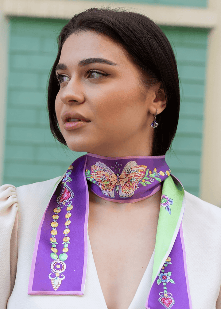 Modischer Seidenschal in Lila und Mintgrün mit kunstvollem Schmetterlingsdesign, stilvoll um den Hals einer jungen Frau getragen – elegantes, handgefertigtes Accessoire für Damenmode