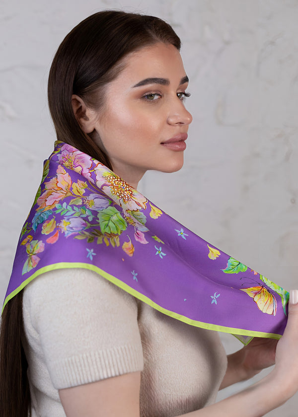 Elegante Frau trägt Designer-Seidenschal Blue Violet 65×65 aus 100 % Twill-Seide  exklusives Blumendesign mit Schmetterlingen, luxuriöses Damenaccessoire von Feinblatt