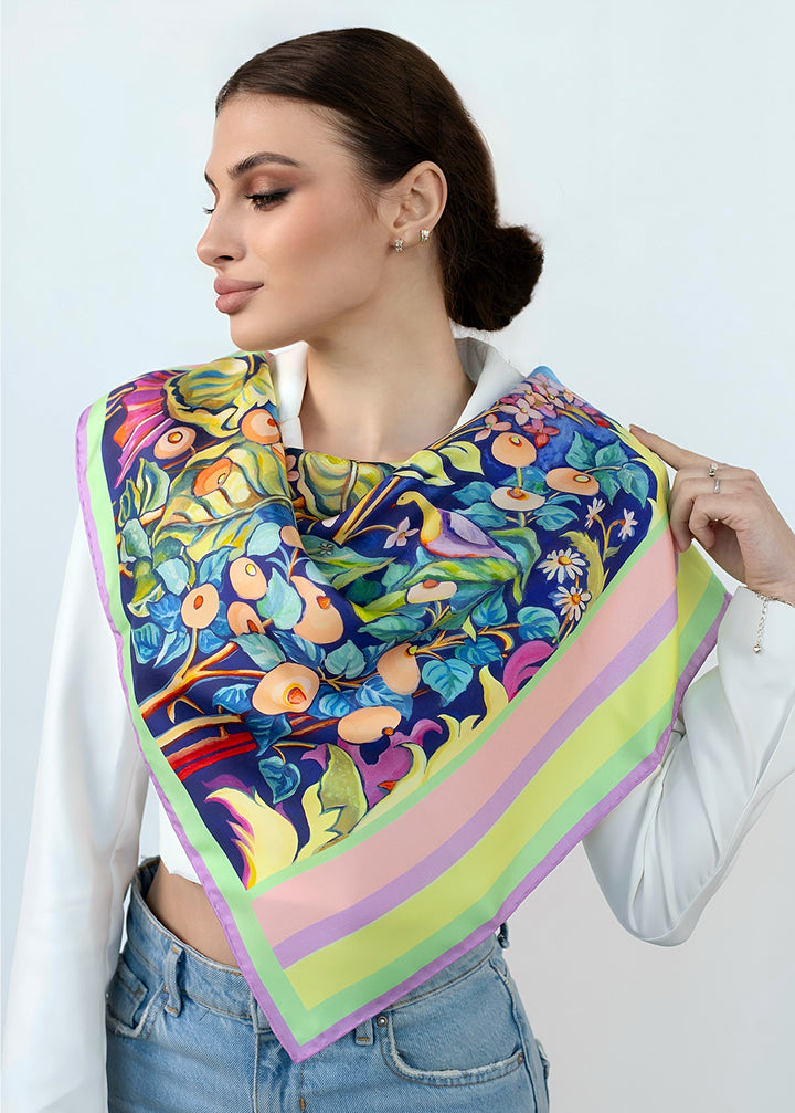Frau mit quadratischem Designer Seidentuch Zauberwald Morgen 65×65 cm aus Twill-Seide, buntes Blumen und Vogelmotiv mit pastellfarbenem Rand